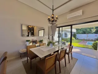 Uma sala de jantar moderna com vista para o quintal.