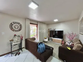 Sala de estar com sofá e televisão em um imóvel no Brasil.