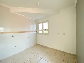Hall de entrada com piso de cerâmica e paredes brancas em uma residência.
