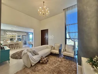 Sala de estar com sofá e poltronas em um ambiente claro.