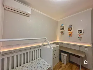 Quarto com cabeceira e armário embutido em ambiente claro.