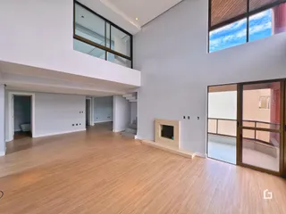 Ambiente amplo com piso de madeira clara e paredes cinzas em um imóvel.