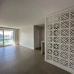 Ambiente interno com piso liso e painel decorativo branco na sala.
