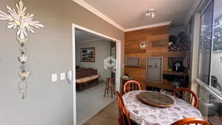 Interior da sala de estar e jantar com piso de madeira e detalhes em painel de madeira.
