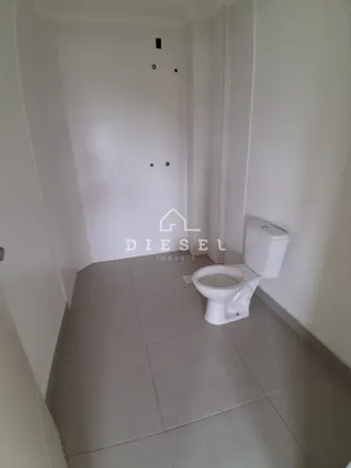 Foto de um banheiro com piso de cerâmica claro.