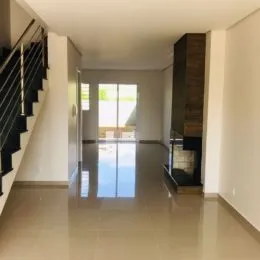 Hall de entrada com piso reflexivo e escadaria visível.