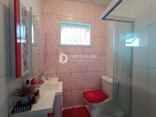 Banheiro com revestimento de cerâmica vermelha e branca.
