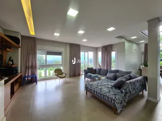 Sala de estar com grande janela e piso de cerâmica clara.