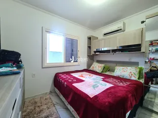 Quarto com cama grande e armários em madeira na residência.