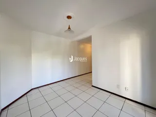 Hall de corredor com piso de cerâmica e paredes brancas.