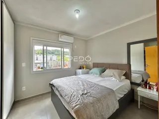 Quarto com cama grande e janela em um imóvel no Brasil.