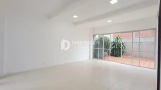 A sala é um espaço amplo com paredes brancas e piso claro.