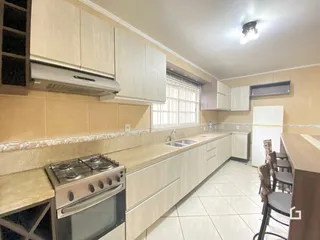 Foto de uma cozinha com armários brancos e piso de cerâmica.