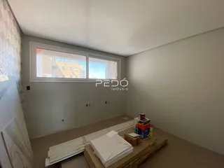 Interior de uma sala de estar com janela grande em um imóvel no Brasil.