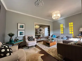 Sala de estar com decoração clássica e piso de madeira.