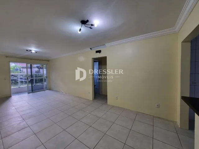 Interior de uma sala com piso de cerâmica e paredes amarelas.