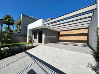 Fachada moderna de uma residência em Lajeado, Brasil, com revestimento de madeira e piso de concreto.