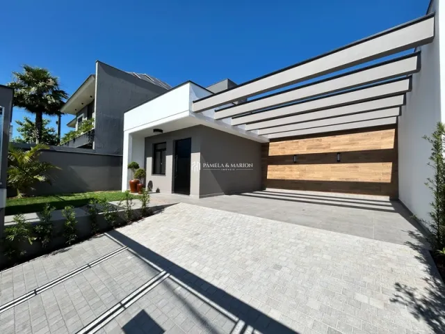Fachada moderna de uma residência em Lajeado, Brasil, com revestimento de madeira e piso de concreto.