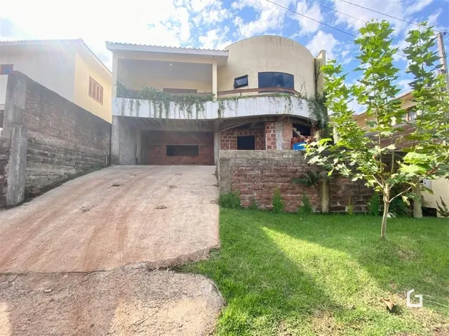 Fachada de uma residência em Lajeado, Brasil, com entrada de garagem e jardim.