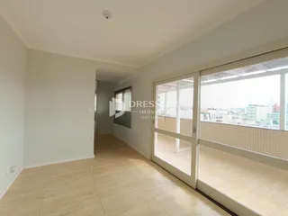 Corredor com piso de madeira clara e portas de vidro que dão para a vista.