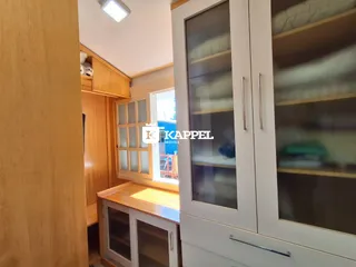 Foto de um ambiente interno mostrando armários de madeira e uma janela.