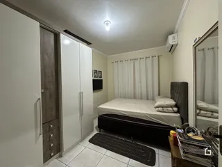 Quarto com cama e armários brancos na sala.