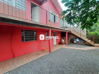 A fachada de uma casa em Lajeado, Brasil, com paredes vermelhas e escadaria lateral.