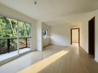 Sala de estar com grande janela de vidro voltada para a natureza.