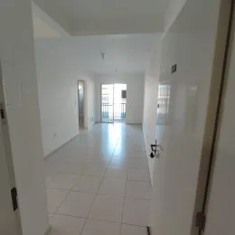 Corredor interno de uma residência com piso claro.