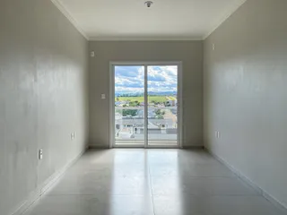 Hall de entrada com piso claro e porta de vidro oferecendo vista para a paisagem.