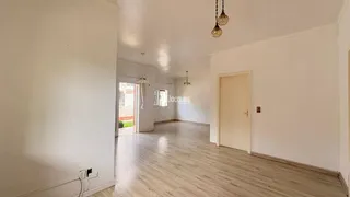 Ambiente interno de uma sala com piso de madeira clara.