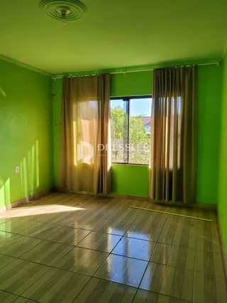 Sala de estar com paredes verdes e piso de cerâmica.