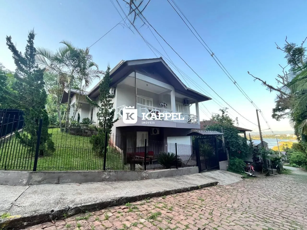 Fachada de uma casa em Lajeado, Brasil, com jardim frontal e cerca de segurança.
