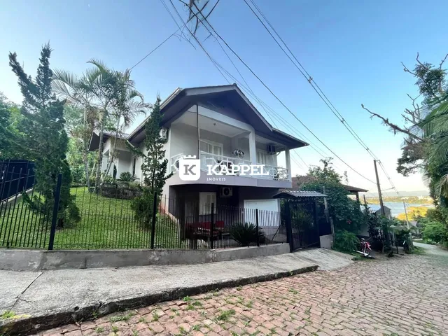 Fachada de uma casa em Lajeado, Brasil, com jardim frontal e cerca de segurança.