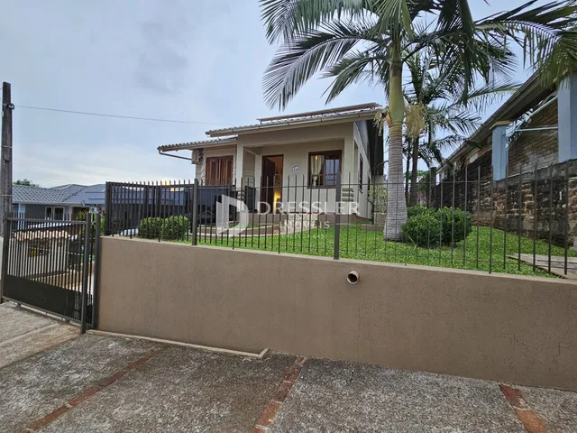 Fachada de uma residência em Lajeado, Brasil, com cerca e muro frontal.
