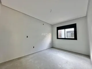 Ambiente interno de uma sala com paredes brancas e piso claro.