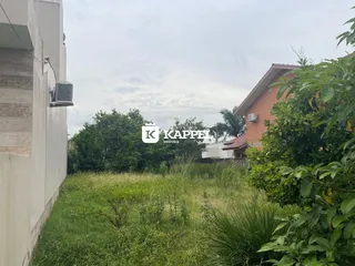 Foto da fachada de uma residência com grama alta no jardim.