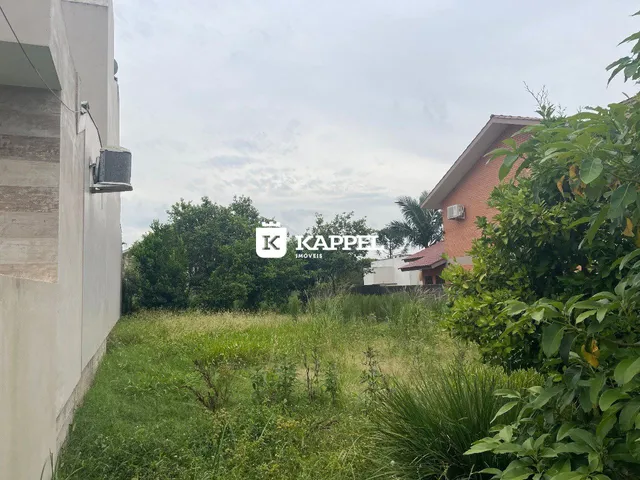 Foto da fachada de uma residência com grama alta no jardim.