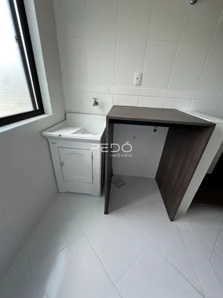 A foto mostra o interior de um banheiro com revestimento branco.