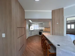 Foto de um ambiente interno com piso de madeira e área de cozinha moderna.