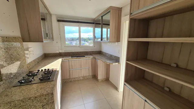Foto interna de uma cozinha com armários e bancadas.