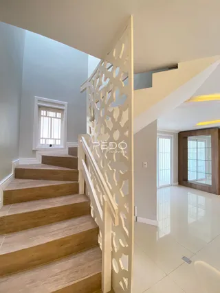 Vista de uma escadaria e parede interna de uma residência.