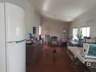 Imagem de uma sala de estar com piso de cerâmica e paredes brancas.