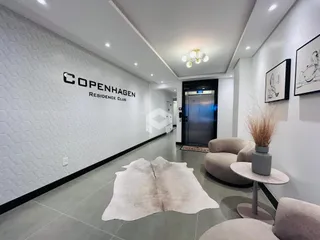 Hall de entrada moderno com paredes brancas e piso claro.