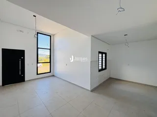 Ambiente interno de uma sala com piso de cerâmica e grande janela.