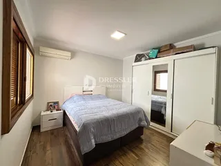 Quarto com cama e armário branco em ambiente claro.