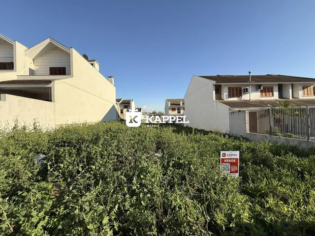 Vista externa de edifícios residenciais em Lajeado, Brasil, com vegetação densa no primeiro plano.