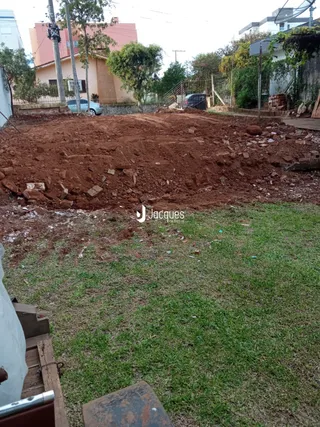 Área externa com terra exposta e grama no quintal de uma propriedade em Lajeado.