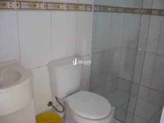 Foto de um banheiro com vaso sanitário e box de vidro.