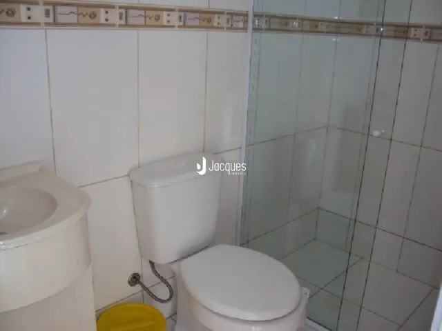 Foto de um banheiro com vaso sanitário e box de vidro.